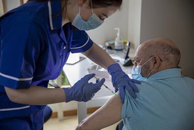Nurse giving older man a COVID-19 vaccine