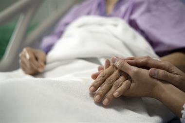 elderly person holding hand of their care worker