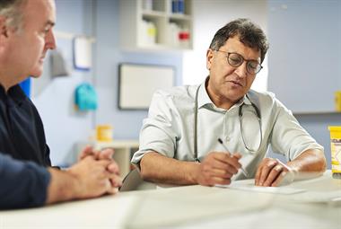 GP writing a prescription during a patient consultation