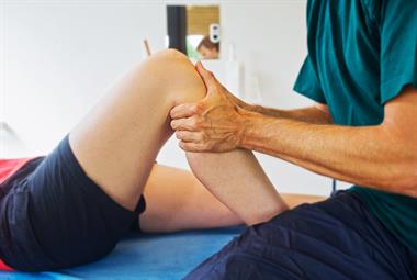 A doctor examining a patient's knee