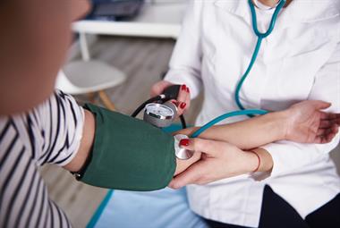 GP taking a patient's blood pressure