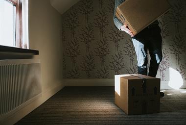 Person lifting box from empty room