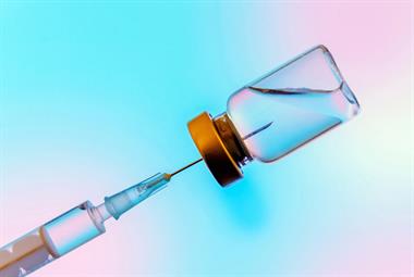Syringe extracting COVID-19 vaccine from vial