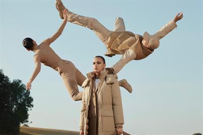 Three models wear Burberry clothes in a gravity-defying pose in its Open Spaces TV ad