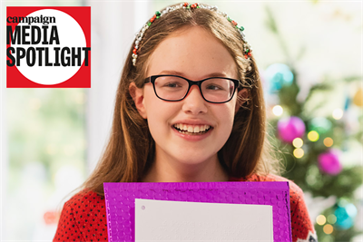 Keira Mills holds up a braille Christmas card