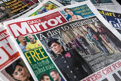 A copy of the Daily Mirror on top of a pile of other newspapers