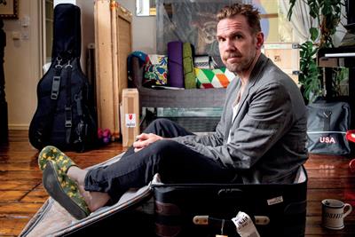 Colour photo of David Kolbusz sitting in an empty suitcase