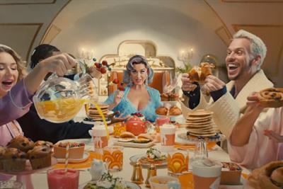 Katy Perry sits at the head of a table filled with food