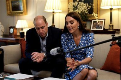 The Duke and Duchess of Cambridge sitting on a sofa with a microphone and papers in front of them