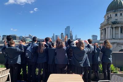 A group of high school students admire the London skyline on a roof terrace at IPG Mediabrands offices