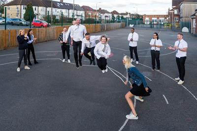 Members of Pablo ad agency team dressed up in school uniform in a playground playing with a skipping rope