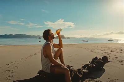 Man drinking Corona’s nonalcoholic beer brand Sunbrew on the beach