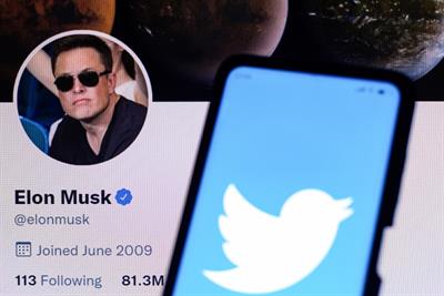 Elon Musk's Twitter account alongside a phone showing Twitter's logo