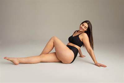 Smiling woman in underwear displaying body confidence concept