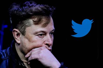 Elon Musk next to Twitter coverage