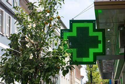 Green neon cross outside a pharmacy