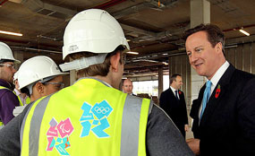 Prime Minister David Cameron speaks to apprentice construction workers at the Olympic Park site in Stratford, East London, yesterday.
