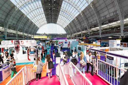 Conference goers in the busy exhibition hall at Olympia, London