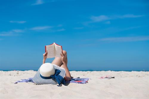 woman reading a book on the beach