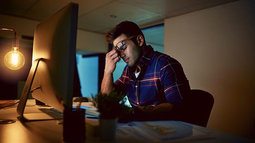 Employee looking stressed at his computer