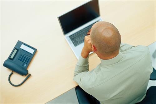 a man working in an office in front of a laptop 