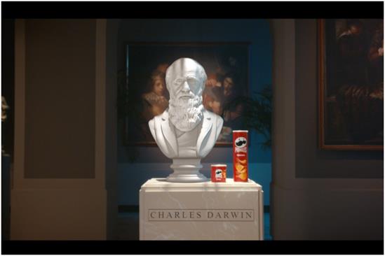 Pringles: Bust of Charles Darwin in a museum next to two cans of Pringles