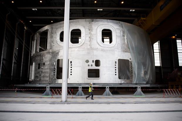 ITER: A technician walks past the lower cyclinder of the cryostat during the launch of the reactor's assembly stage this week. Image: Clement Mahoudeau/AFP
