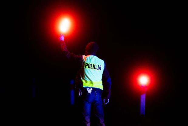 A police officer checks vehicles entering a checkpoint near the village of Bialowieza, eastern Poland, November 2021. The government has begun building a border wall with Belarus nearby. Photo: Mateusz Slodkowski / AFP via Getty
