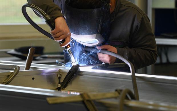 A worker welds in a production hall of a German ladder, stool and scaffold-maker in Guenzburg, January 2022. Photo: Thomas Kienzle/AFP /AFP via Getty Images