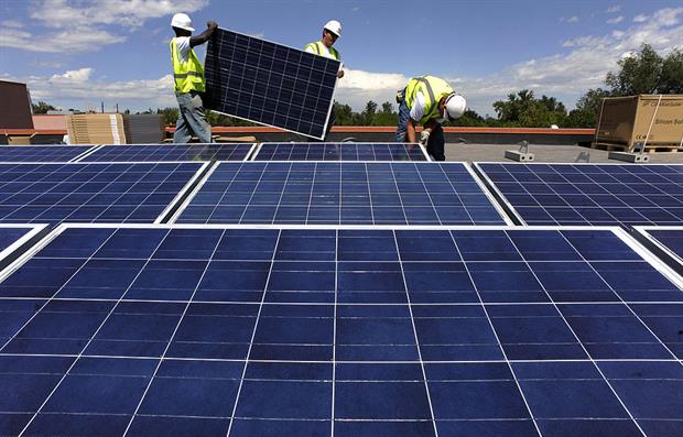 Workers install solar PV on a school in Denver, in the US. In the EU, community energy groups are worried that draft changes to state aid rules may make it harder for them to operate. Photo: Helen H. Richardson/The Denver Post via Getty Images