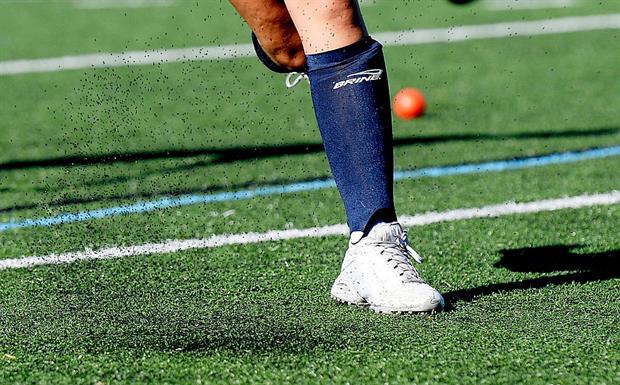 Rubber crumb infill spraying up as a hockey player drives a ball on artificial turf. Photo by Shawn Patrick Ouellette/Portland Portland Press Herald via Getty Images