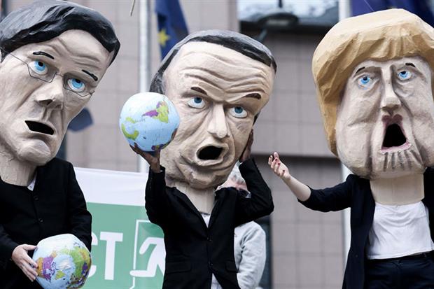 Brussels, July 2021: Environmental activists wearing masks urge EU leaders to exit the Energy Charter Treaty (Photo by KENZO TRIBOUILLARD/AFP via Getty Images)