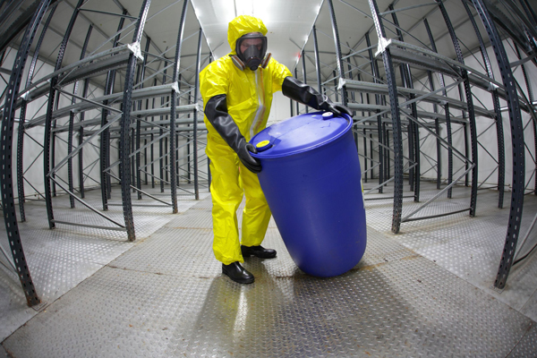 Chemicals, safety suited worker handles barrel (photograph: Marcin Balcerzak/123RF)