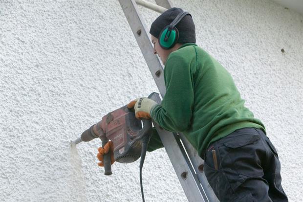 A builder installs cavity wall insulation in a house in Cumbria, UK. Investment in energy efficiency would have an immediate impact of job creation, the European Commission has said. Photo: Ashley Cooper/Construction Photography/Getty
