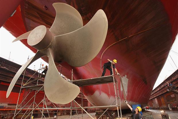 Workers remove scaffolding after maintenance work on a cargo ship's propeller in Hamburg, Germany. The shipping industry is responsible for around 3% of global CO2 emissions. Photo: Photo by Sean Gallup/Getty Images
