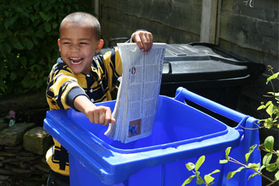 Boy putting paper in blue recyling bin (credit: Royal Borough of Windsor and Maidenhead)