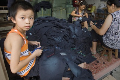 A young boy is working with his parents at a small jeans workshop in Dadun Village in Xintang, Zengcheng (credit: Lu Guang / Greenpeace)