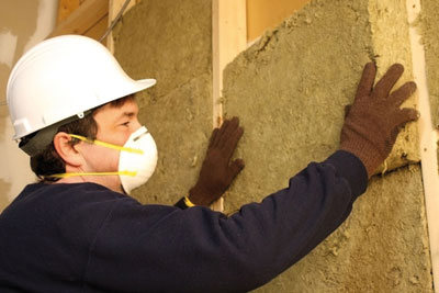 Insulation being installed in wall (credit: dreamstime.com)