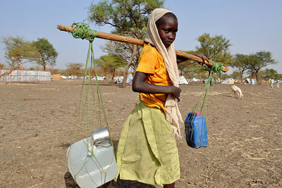 Young girl carrying water in South Sudan (photograph: Alun McDonald/Oxfam)