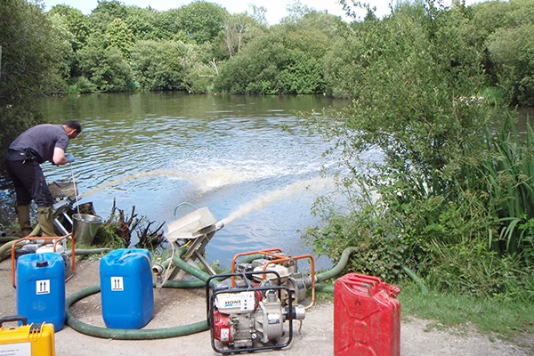 Environment Agency staff working to restore dissolved oxygen levels at Par Pond where hundreds of small coarse fish died. Photograph: Environment Agency