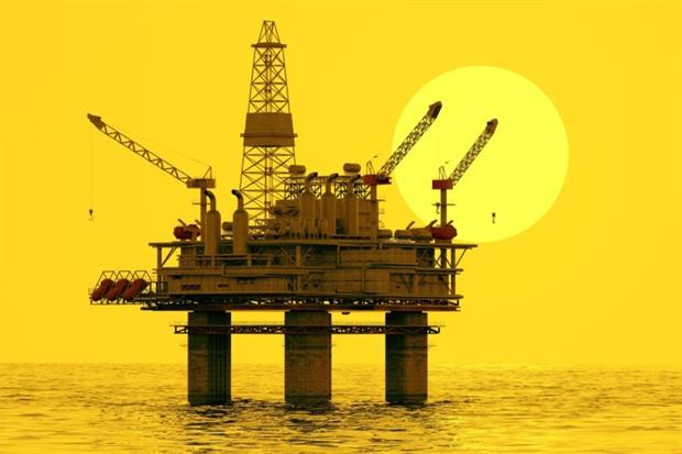 offshore oil and gas rig silhouette against sun