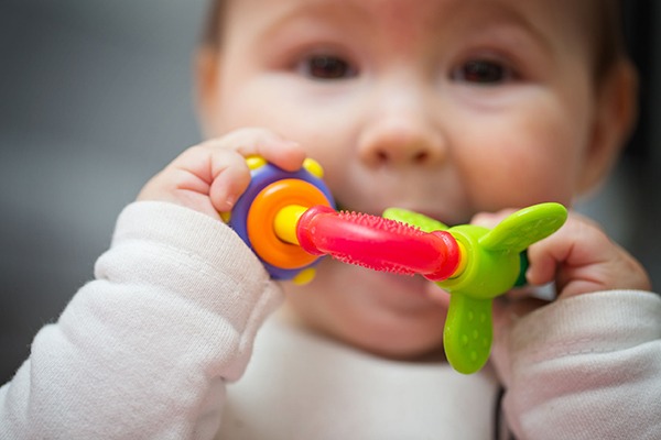Baby playing with plastic toy. Photograph: Deymos/123RF