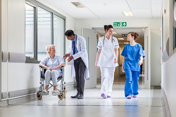 Doctor talking to woman in wheelchair in hospital corridor. Photograph: Spotmatikphoto/123RF