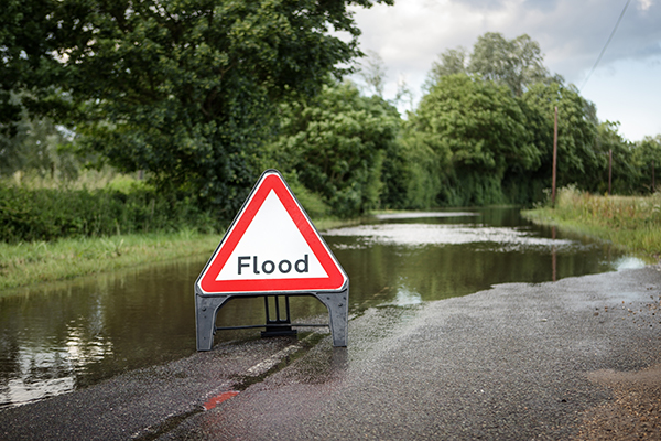 Flood warning sign on flooded road