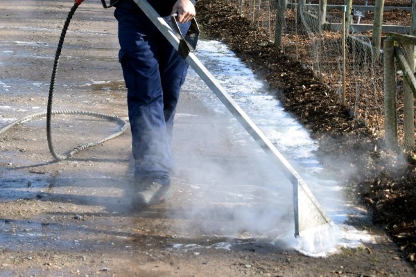 Worker using Foamstream to kill weeds