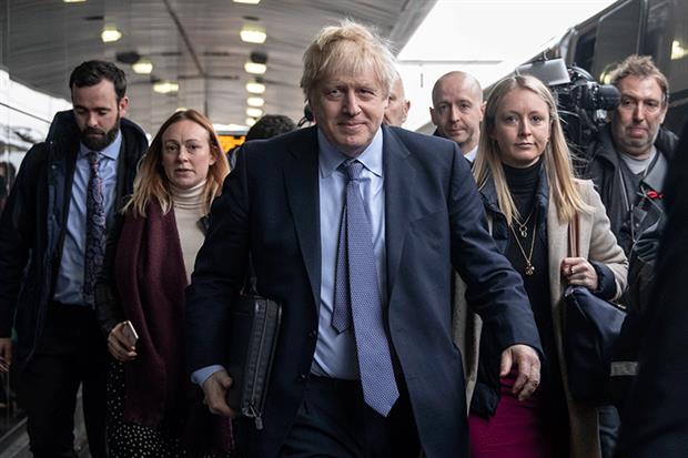 Boris Johnson surrounded by aides and journalists on his way to launch his manifesto. Photograph: Dan Kitwood/Getty Images