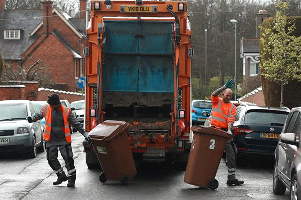 Refuse collectors acknowledge the applause from local residents as waste bins are collected in Northampton. Photograph: David Rogers/Getty Images