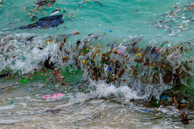 A wave carrying plastic waste on a beach in Koh Samui, Thailand, January 2021. Proponents says a global treaty is needed because plastic waste is a transboundary pollutant. Photo by Mladen Antonov/AFP via Getty Images