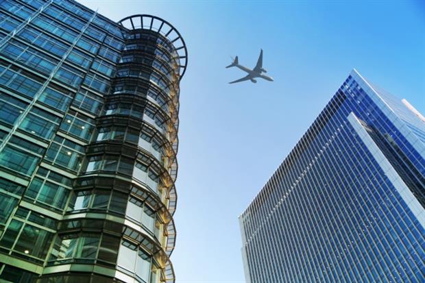 Airplane flying over skyscrapers