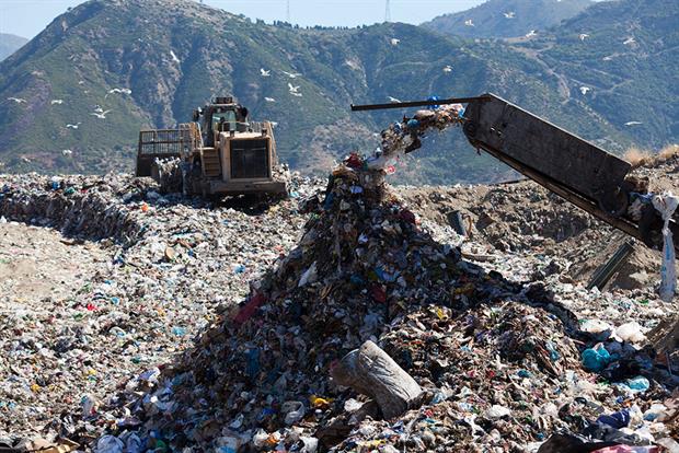 Waste being deposited by machinery at a landfill 
